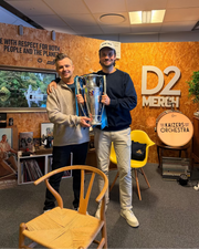 Daniel Engen og David Møller holder Viking FK sin seriemester pokal i showrommet til D2 Merch på Tasta.